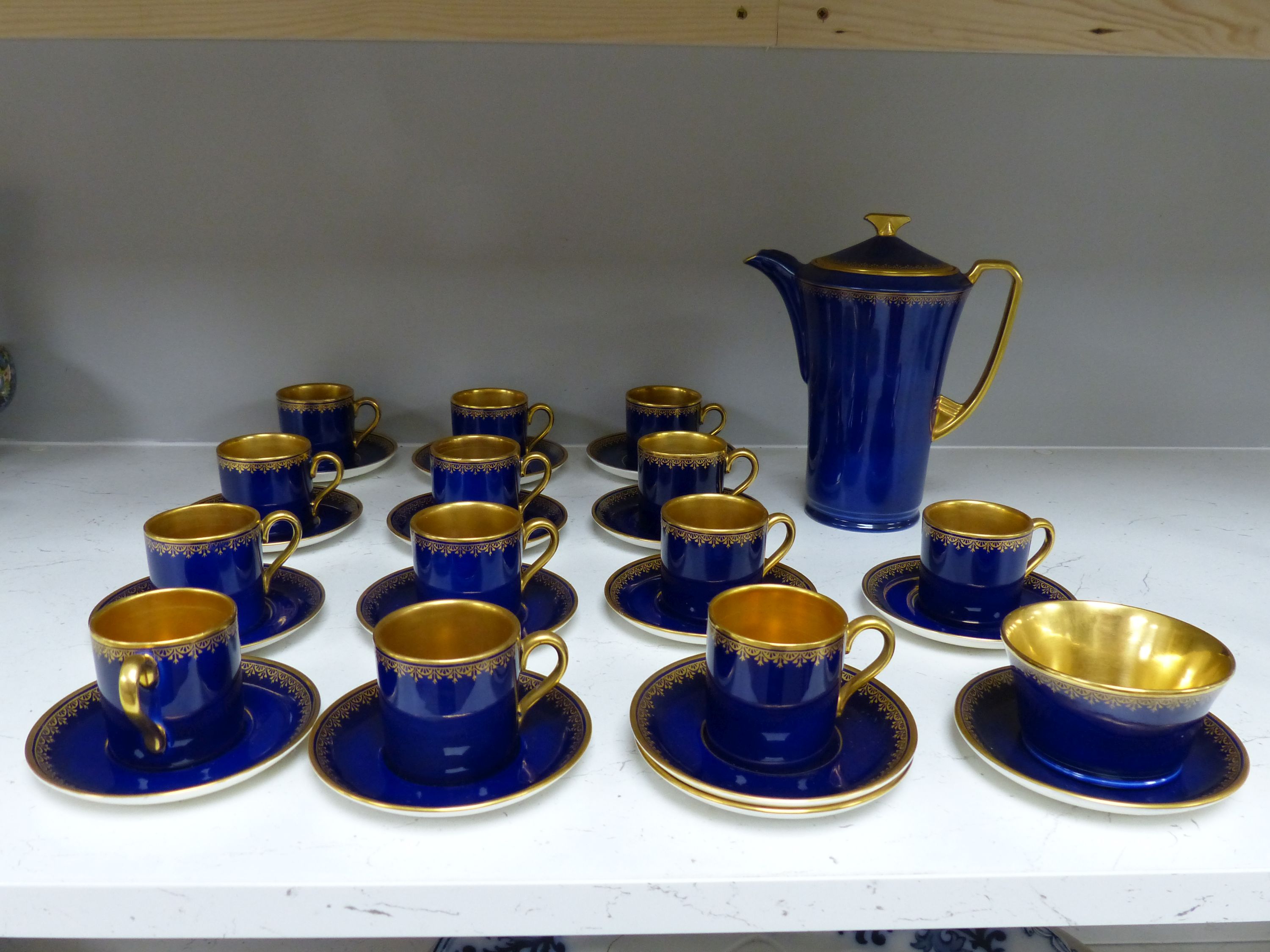 A Crown Devon Fieldings part coffee service, cobalt blue with gilt interiors and patterned rims,